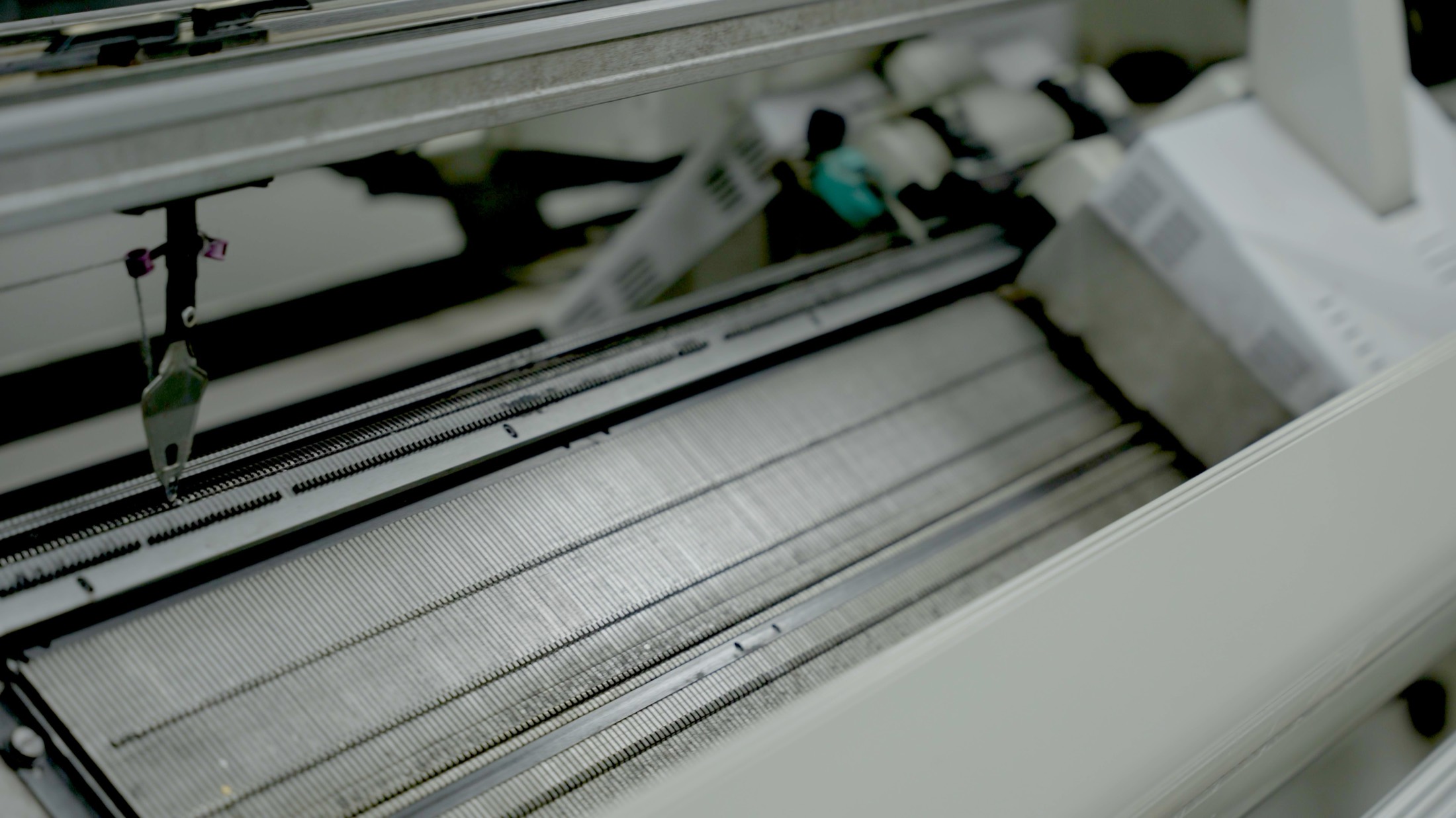 Close view of the needle bed of an industrial knitting machine